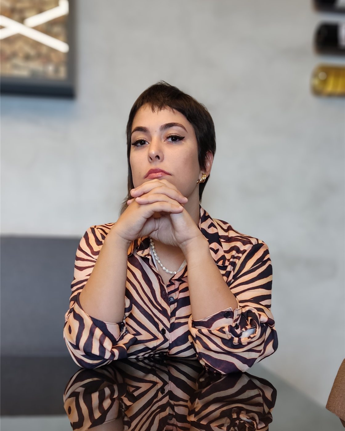 Dra. Francieli Zambonini à mesa de reuniões, com as mãos cruzadas